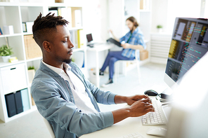 Serious it-manager sitting by desk, typing and coding data or analyzing new database