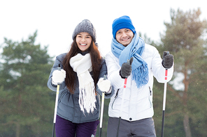 Two young happy skiers looking at camera while enjoying winter day in park