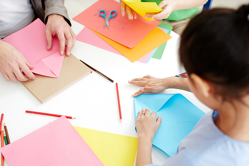 Secondary school learners using pink and blue paper while making origami