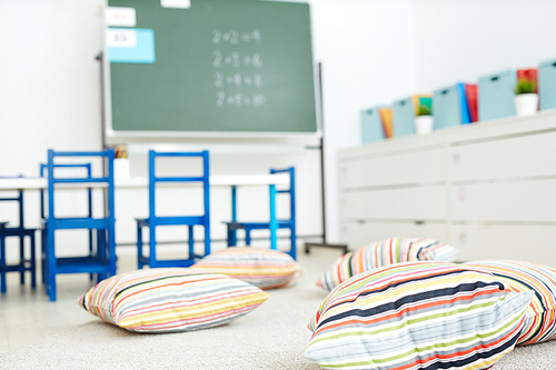 Empty classroom in modern school with soft striped pillows on the floor