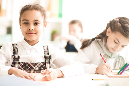 Portrait of African schoolgirl sitting at desk during a lesson