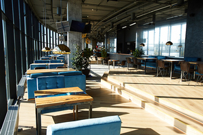 Sunlight penetrating through cafe window on wooden floor and furniture