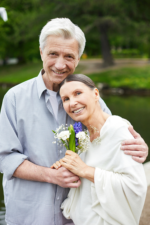 Happy senior man embracing his wife and both  during walk in park