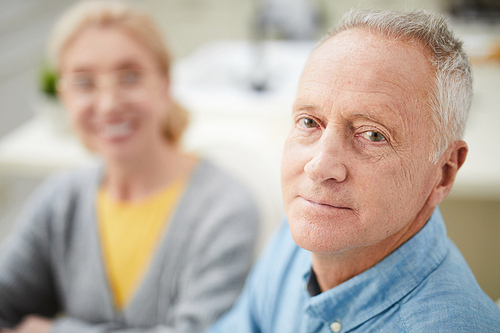 Senior man and his happy wife on background  while staying at home