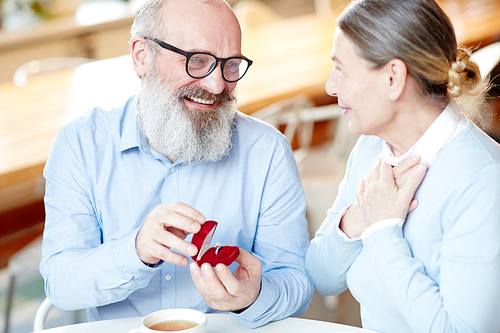 Senior man giving ring to his wife for some family occasion or holiday