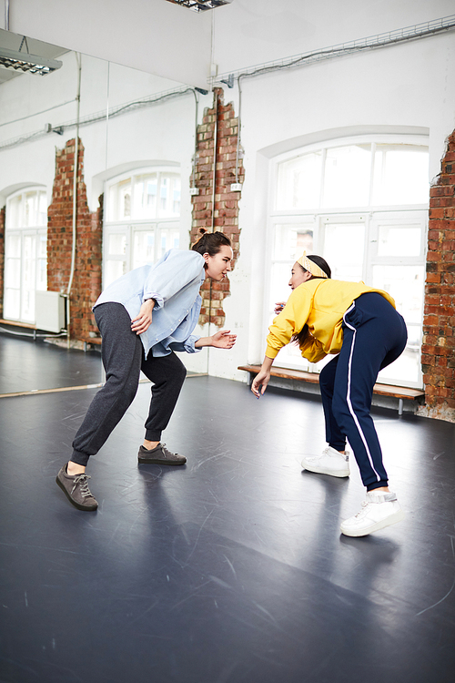 Breakdance trainer and her learner training together in front of one another in studio