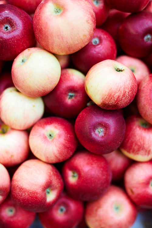 Close-up of fresh ripe red apples stacking in food store, fruit background