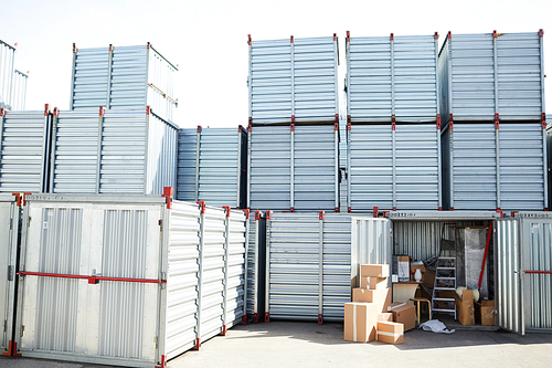 Several large storage containers with heap of boxes near by and work supplies in one of them