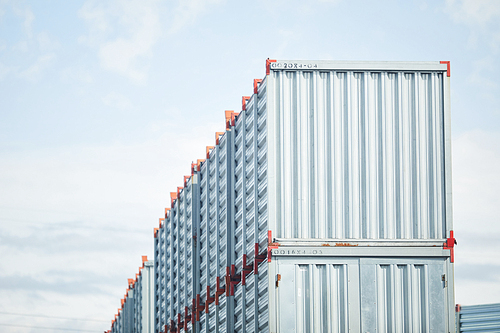 Top row of new metallic storage containers somewhere by load and transportation factory