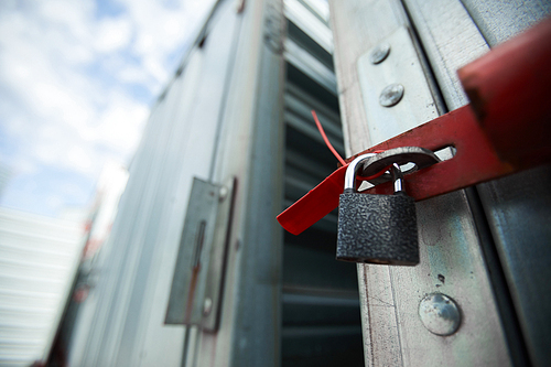 Close-up of closed cargo container on lock, sealed container in warehouse area