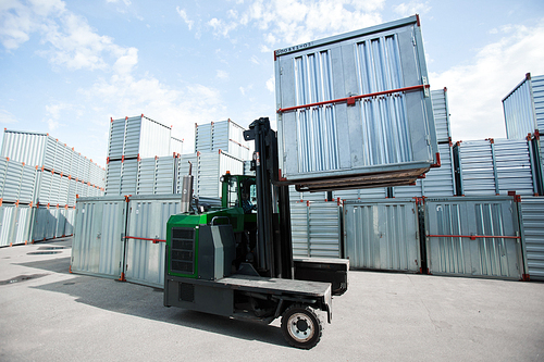 Load machine with one of storage container moving along territory of transportation company
