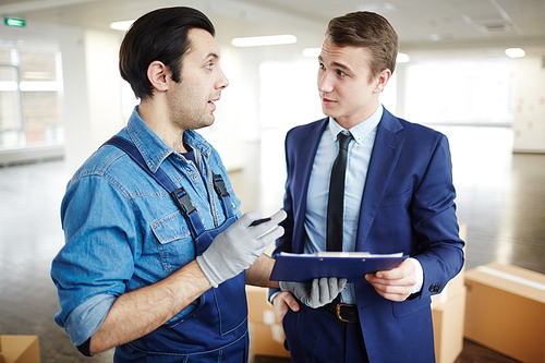 Young businessman and relocation office staff discussing terms of agreement after making service