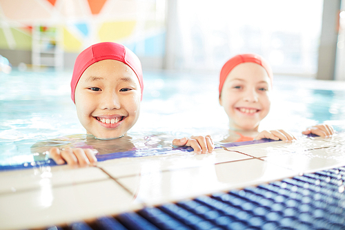 Youthful swimmers  with smiles while standing in water