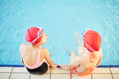 overview of two 20대 여성friends in swimwear spending time by swimming-pool after school