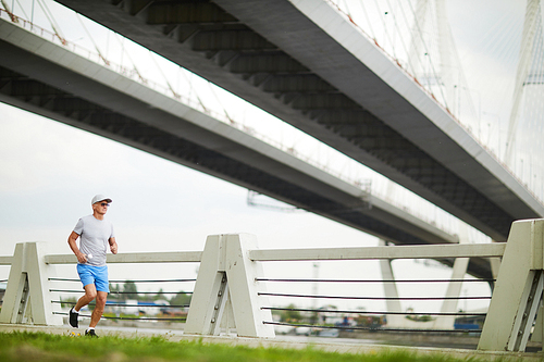 mature sportsman in activewear having workout in the morning in urban