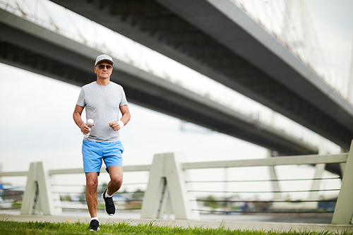 senior man in sportswear enjoying jogging workout in urban