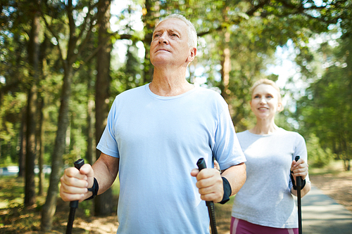 active aged man and woman in sportswear enjoying summer day in natural  while trekking