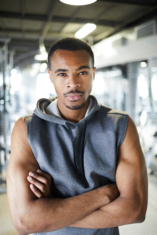 Strong young African-american sportsman crossing arms on chest while standing in front of camera