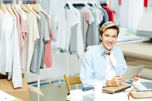 Portrait of smiling fashion designer working at her table