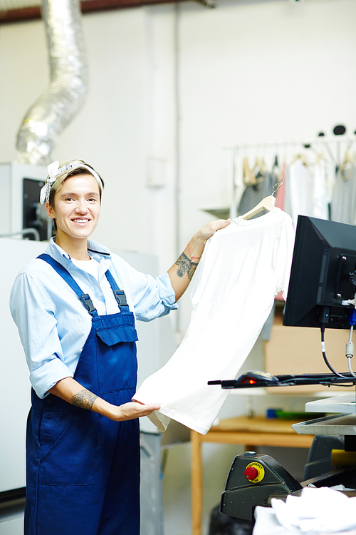 Female operator making print on shirt on workshop