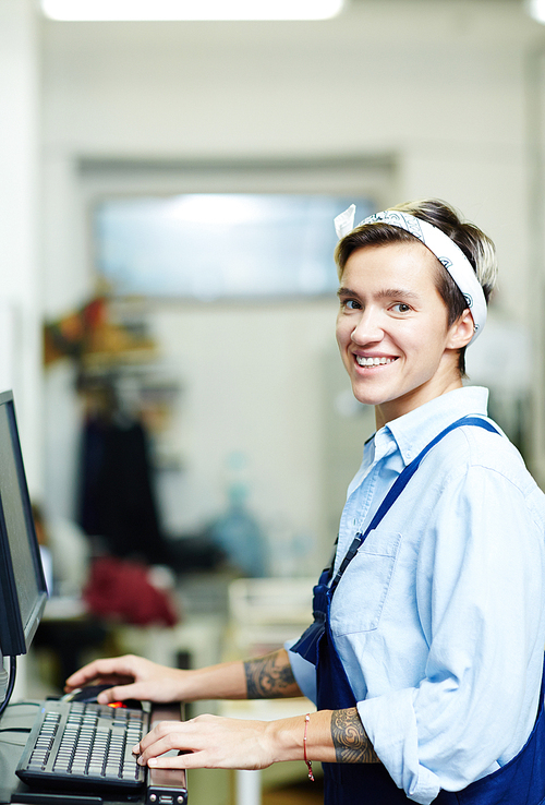 Female operator typing on computer in printing house