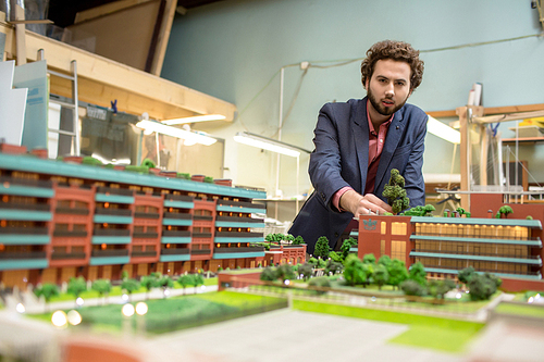 Young architect working over new district of modern city in workshop