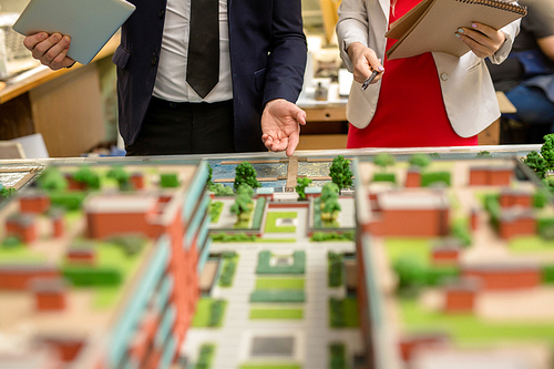 One of architect pointing at part of city layout during presentation of his project