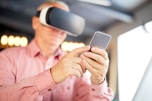Senior businessman in vr headset using his smartphone while watching webcast