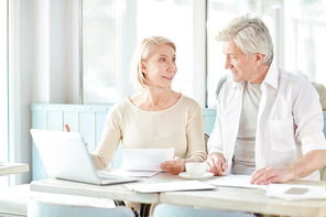 Two senior agents having meeting in cafe where discussing information for presentation