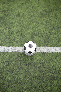 Overview of soccer ball in the center of white line on green football field