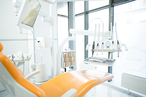 Contemporary equipment for dental check-up with armchair for patient near by