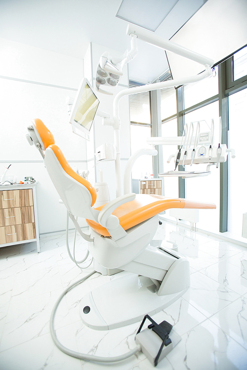 Interior of contemporary dental clinics with modern equipment and leather armchair for patients