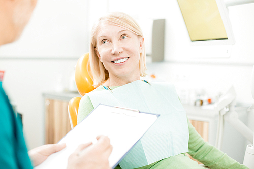 Smiling patient listening to her dentist recommendations after chack-up or healing teeth