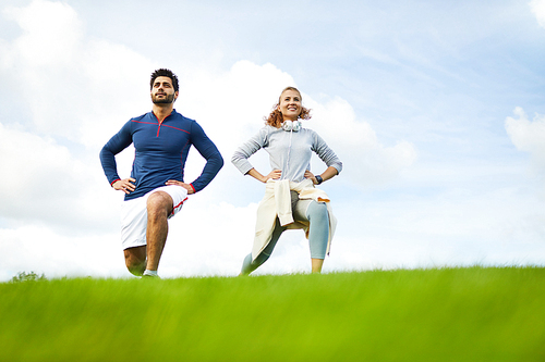 Happy young sporty woman and man enjoying their morning workout in natural environment