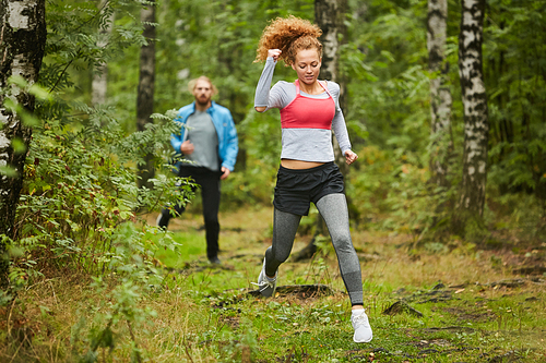 young active couple in sportswear running in natural  on summer morning before workout