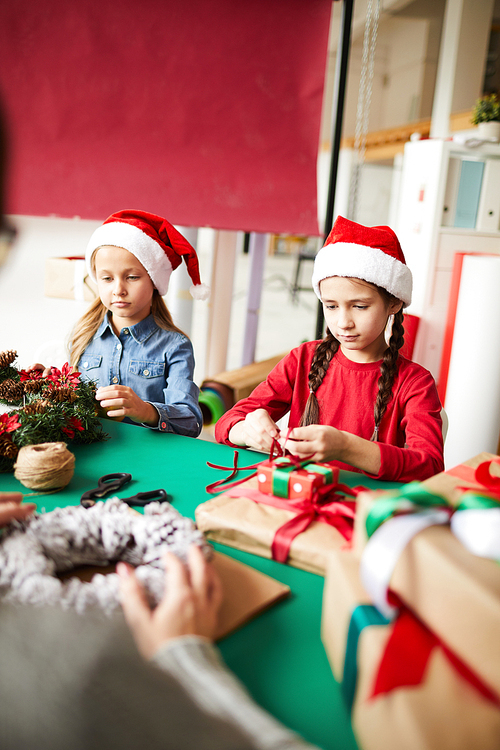 Two cute little siblings in xmas caps helping their mom with preparations for holiday