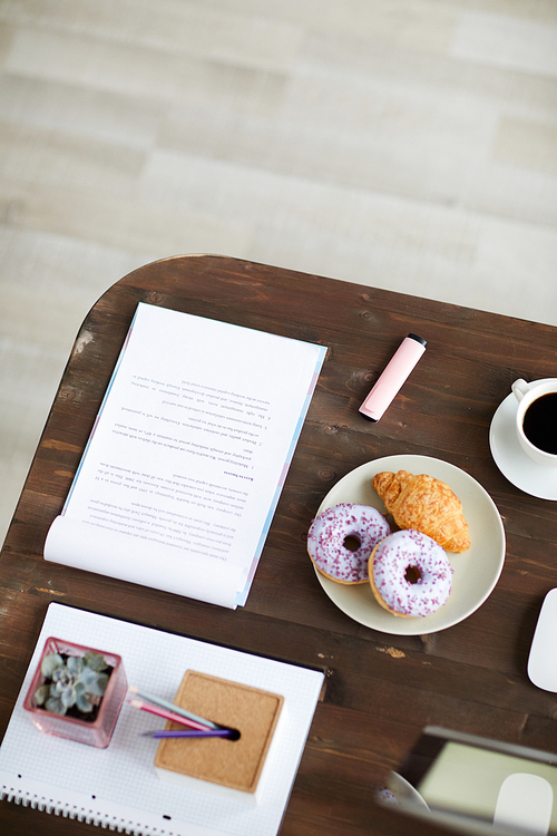 Business document, stationary, snack and cup of coffee on workplace of designer