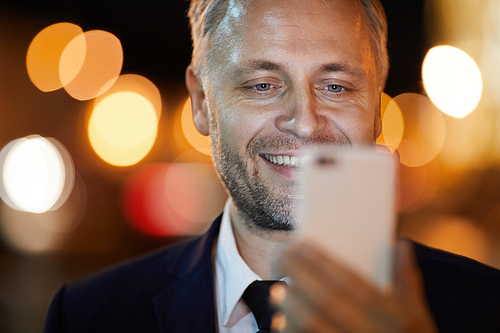 Smiling businessman  of smartphone while posing for selfie