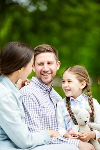 young parents and their little daughter enjoying summer weekend in natural