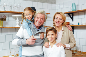 Happy family of mature man, his wife and their two grandchildren 