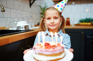 Happy girl with birthday cake  through burning candles