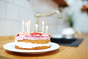 Fresh and tasty homemade birthday cake with burning candles on table