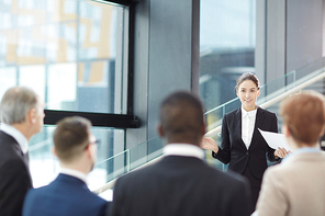 Young elegant businesswoman making report for her colleagues during or before conference