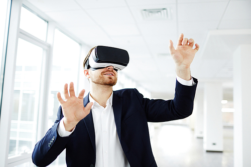 Businessman making gestures when wearing virtual reality goggles