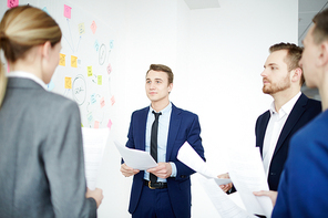 Young business people with reports speaking at a meeting at office