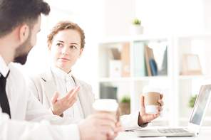 Two coworkers planning work and drinking coffee