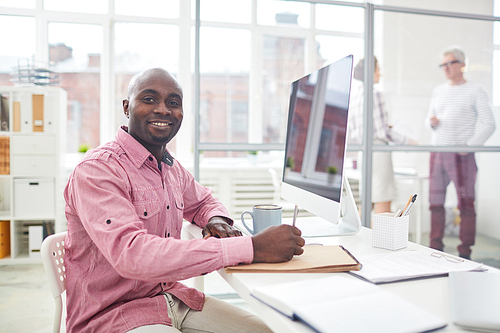 Young African-american businessman  while making working notes