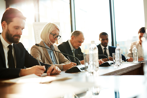 유토이미지 | Row of serious delegates making notes while sitting in ...