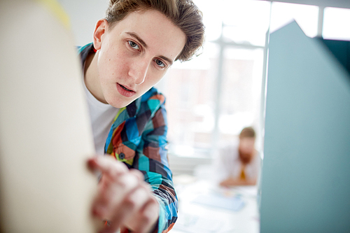 Businessman taking file from shelf at office