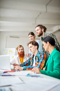 Group of designers working together on a creative project on laptop